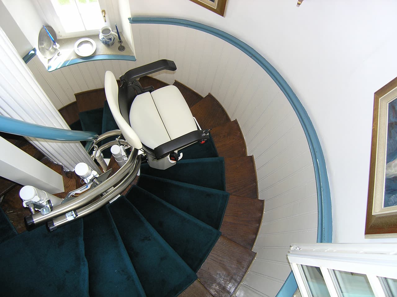 Ein Treppenlift auf einer Wendeltreppe in einem Einfamilienhaus