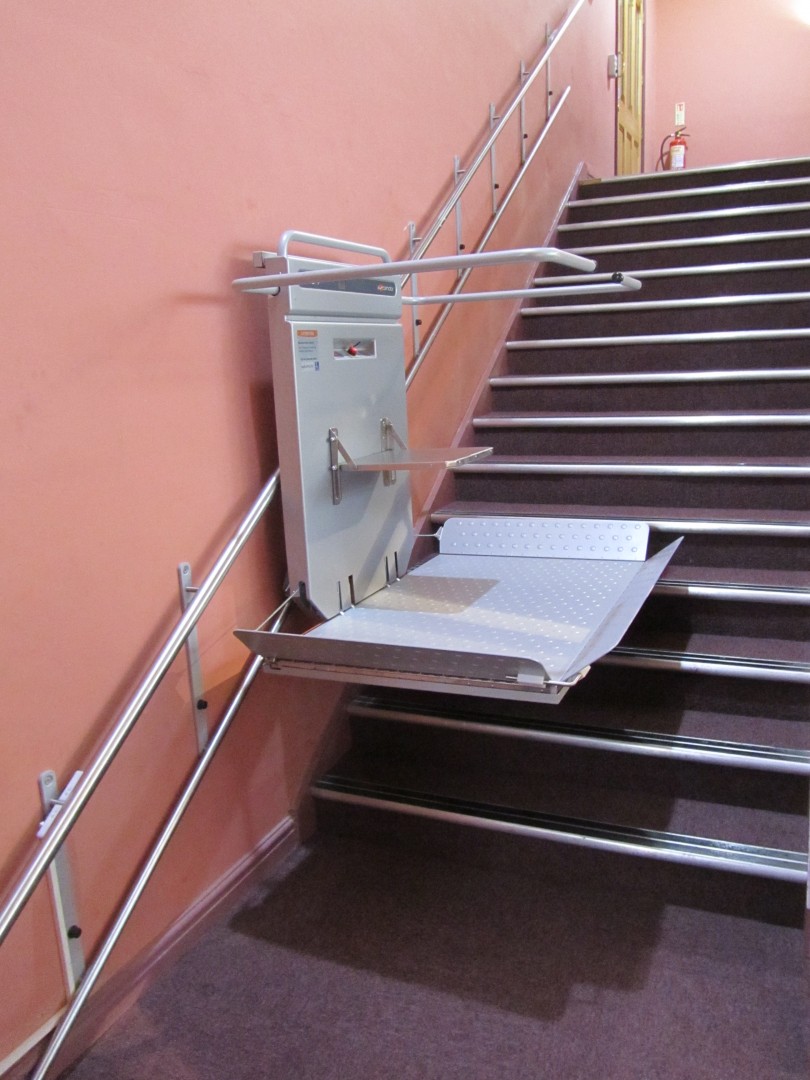 02 Plattformlift fuer Rollstuhlfahrer gerade Treppe Plattformlift PLG7 mit Klappsitz, Wandmontage für minimalen Platzbedarf, Lift während der Fahrt