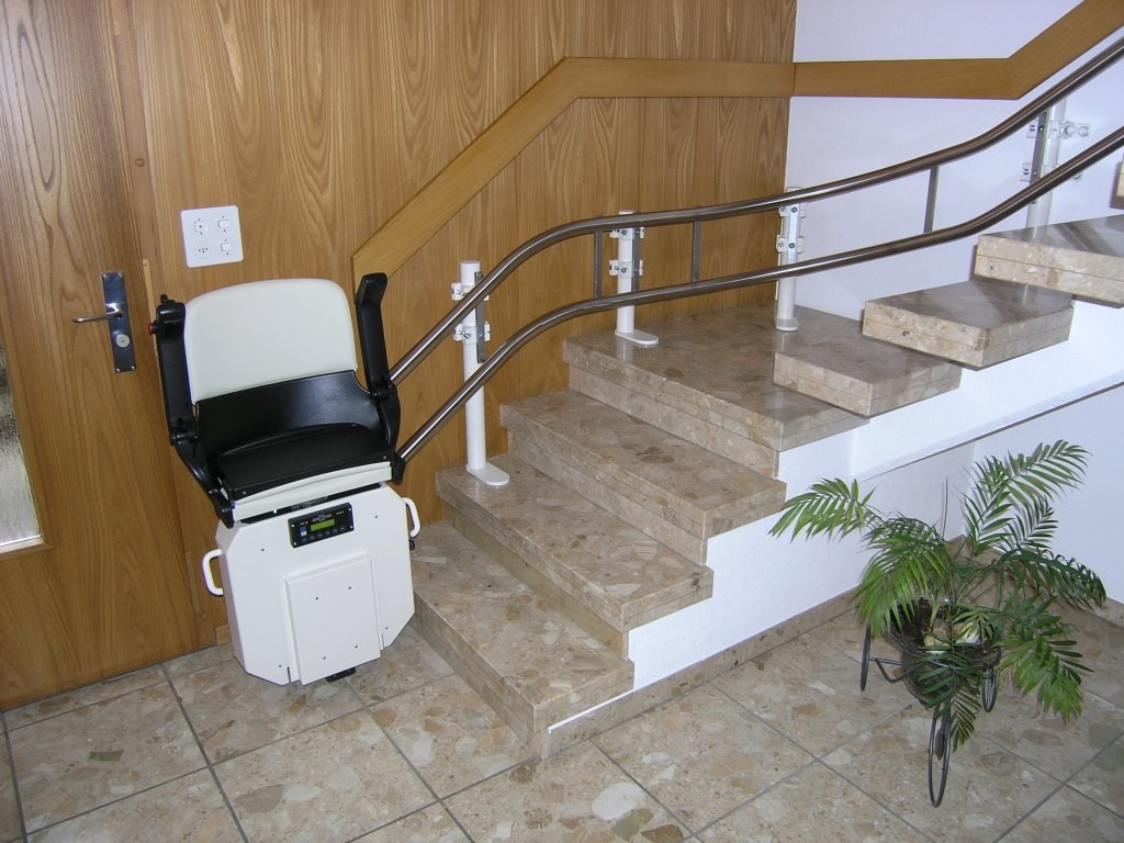 06-Treppenlift-Aussenlaeufer-Stuetzen-augestellt-ohne-bohren-Sitzlift-zu Treppenlift, Montage ohne bohren der Stufen, Sitzlift untere Haltestelle platzsparend zusammengeklappt