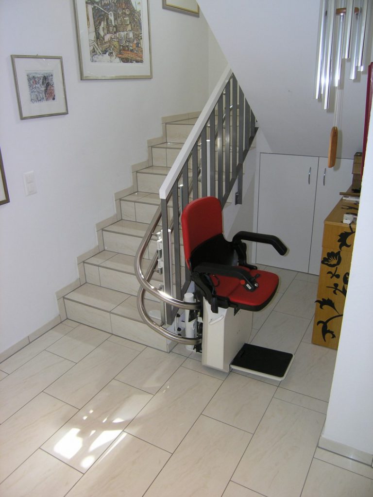 Treppenlift in unterer Haltestelle, seitlich der Treppe, nach 180°-Kurve