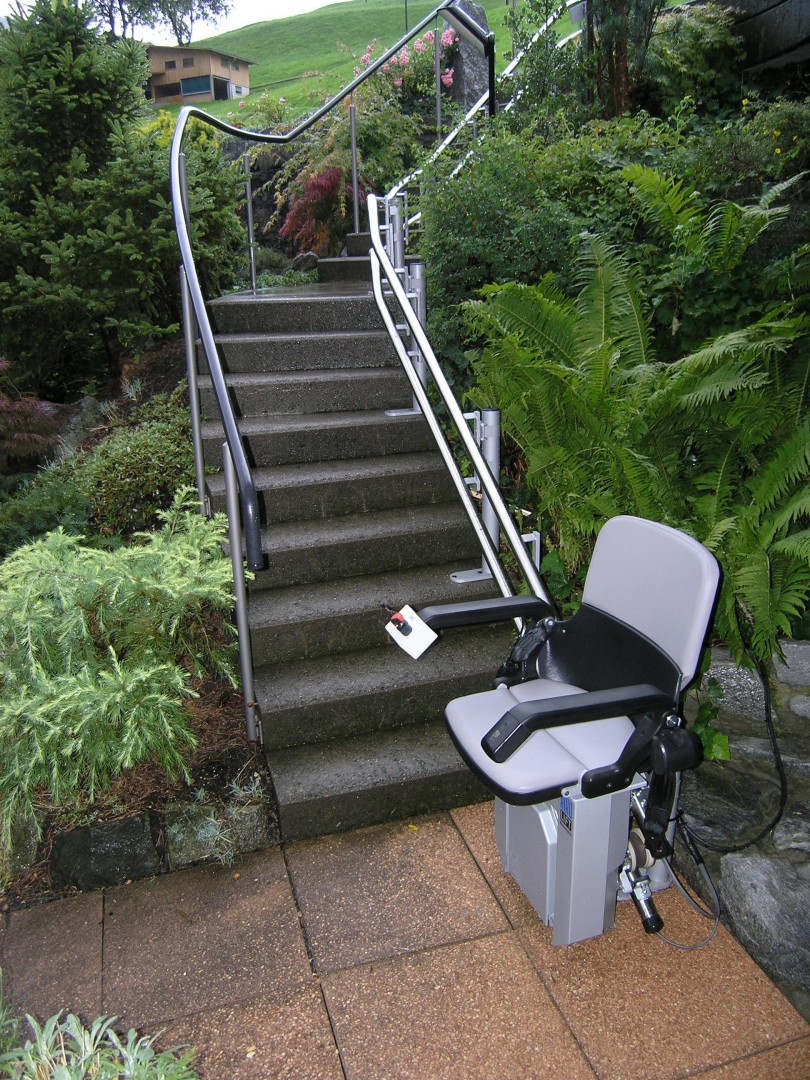 09-Treppenlift-aussen-wetterfeste-asfuehrung-treppe-Garten Treppenlift aussen über kurvige Treppe im Garten, witterungsbeständige Ausführung